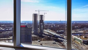 Blick auf eine Stadtlandschaft mit einem Gebäude mit der Aufschrift 'UKOIL' und mehreren Baukränen.