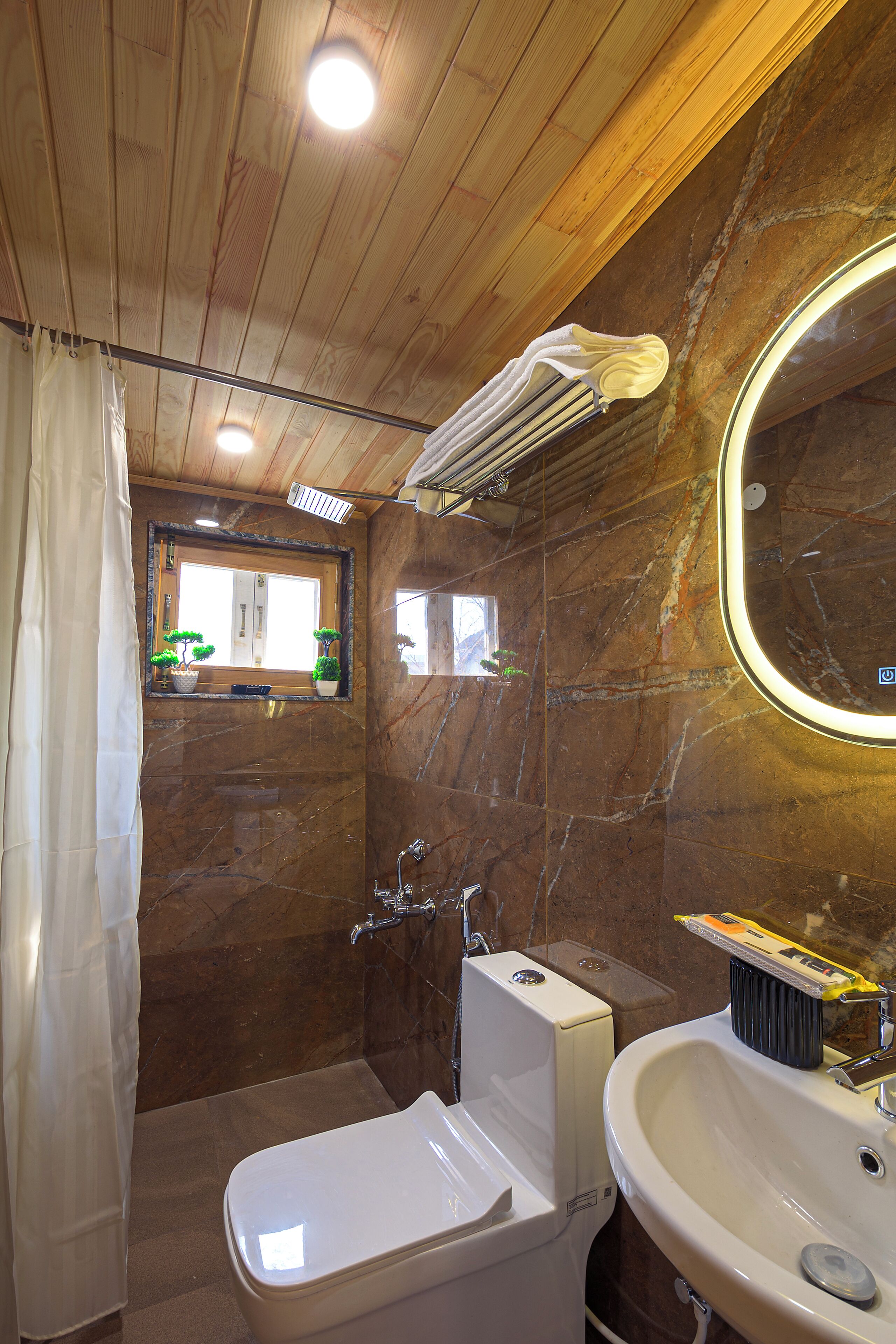 A bathroom with a white toilet, a sink, a mirror, and a shower curtain.