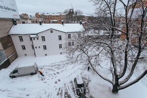 A building with multiple windows and a snow-covered roof. - Pernavas studio loft with free parking (Riga)