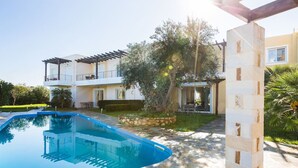 Une maison moderne à deux étages dotée d’une piscine, d’un espace salon extérieur et d’une pergola.