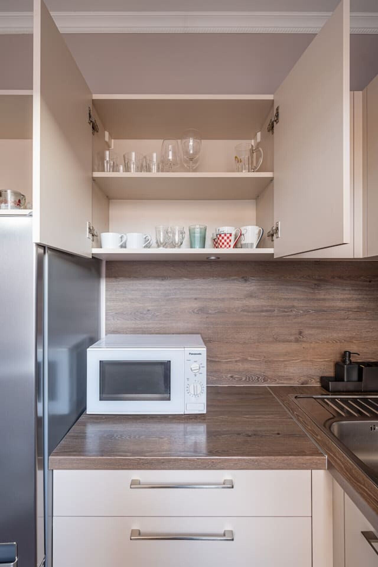 Eine Küche mit Mikrowelle, Holz Arbeitsplatte und Schränken.