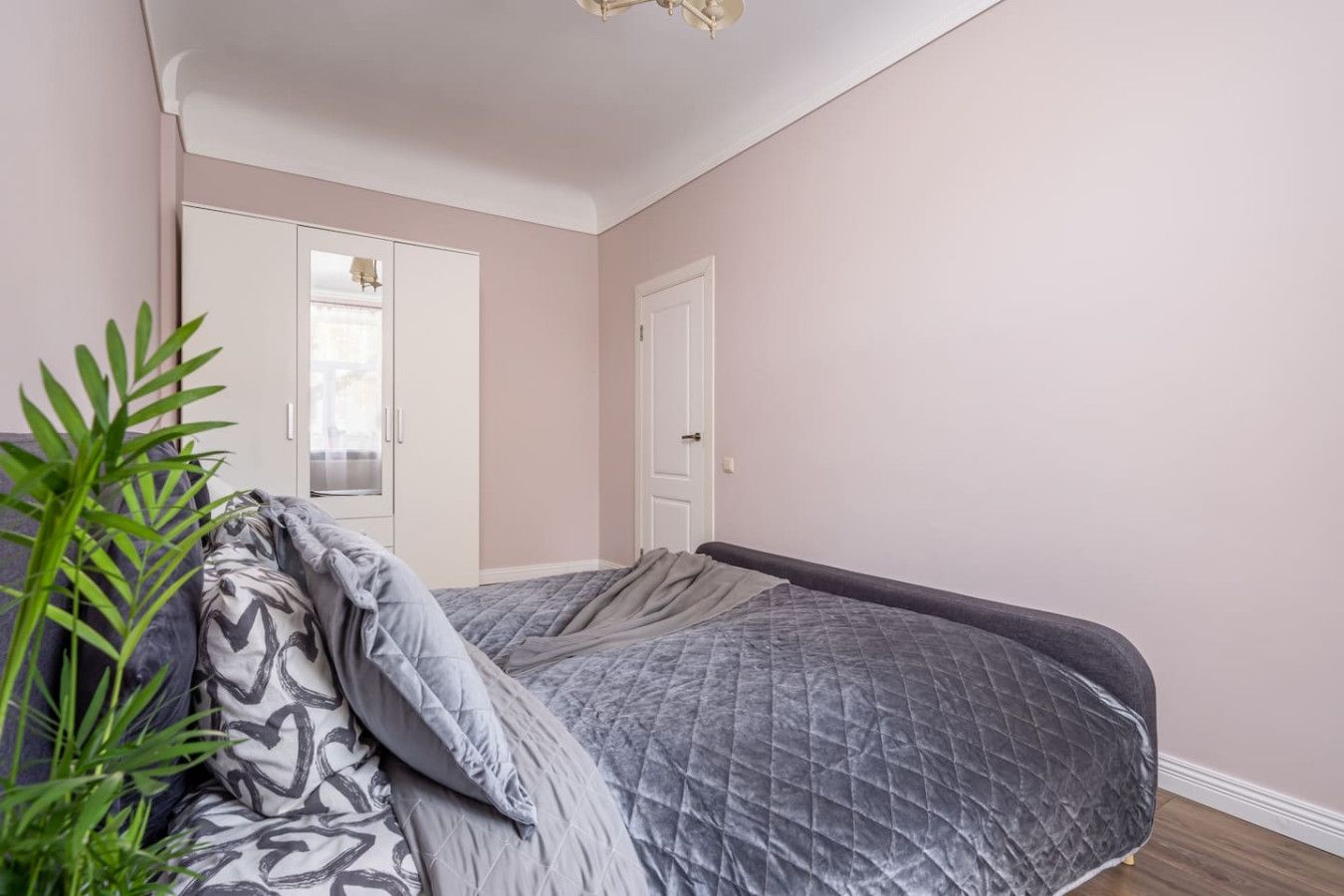 A bedroom with a bed, a wardrobe, and a door.