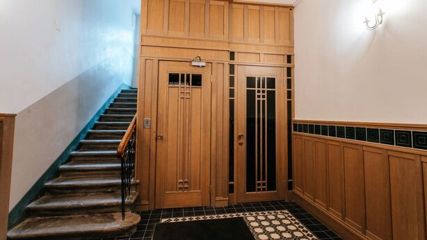 A wooden staircase leading to a door with a decorative glass panel. - Hanzas residence near ArtNouveau quarter & OldTown (Riga)