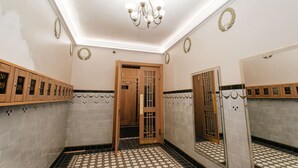 A bathroom with a tiled floor, a wooden door, a mirror, and a chandelier. - Hanzas residence near ArtNouveau quarter & OldTown (Riga)