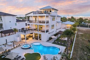 Um edifício residencial com vários andares, piscina, área de estar externa e varanda.