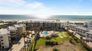 Un hôtel doté d’une piscine, offrant une vue sur la plage et comprenant plusieurs bâtiments.