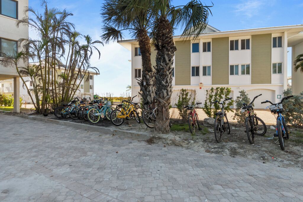 A paved area with bicycles parked along the side of a building.