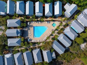 An aerial view of a resort with multiple buildings, a central swimming pool, and surrounding lounge areas. - ☀️Gated Community with Pool-Close to Beach-Barefoot Cottage B37👣 (St. Joe Beach)