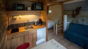 A compact cabin with a kitchenette, a small dining area, and a view of the sea. - Charming Chalet in Sint Maartenszee (Sint Maartensvlotbrug)