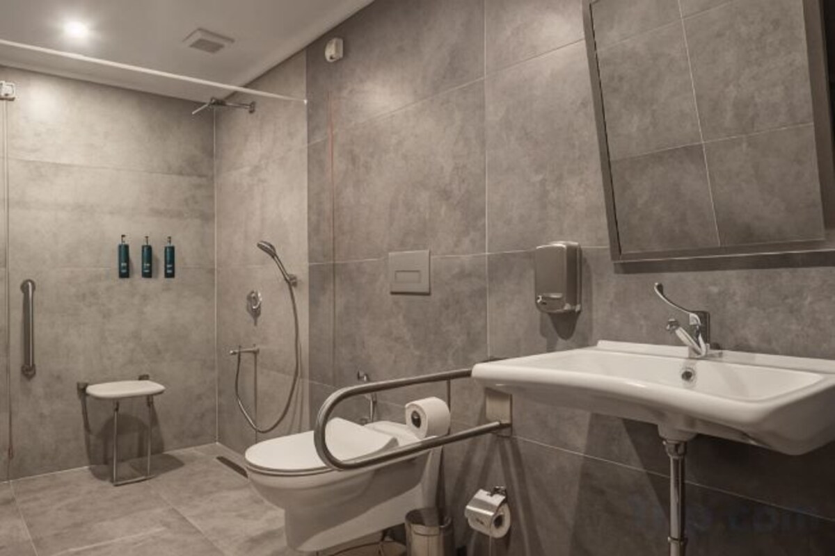 Un baño moderno con ducha, inodoro y lavamanos.
