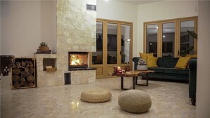 A cozy living room with a stone fireplace, a green sofa, and a wooden coffee table.