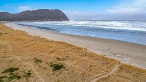 Une plage d’où l’on a une vue dégagée sur l’océan et sur une montagne lointaine.