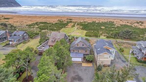Une zone résidentielle côtière avec des maisons, une plage et une montagne en arrière-plan.