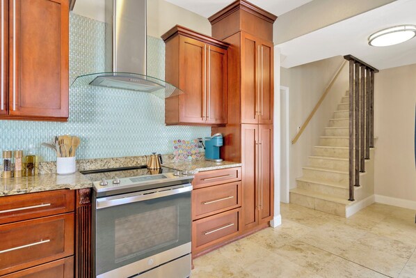 A kitchen with wooden cabinets, a stainless steel stove, and a tiled backsplash.