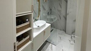 A modern bathroom with a vanity, sink, and shower. - Tirana Garden Apartments (Tirana)