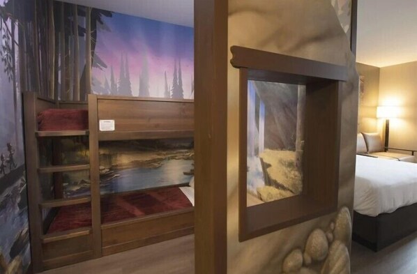 A room with a bed, a window with a view of a forest, and a wall with a mural of a forest scene. - Great Wolf Lodge Naples (Naples)