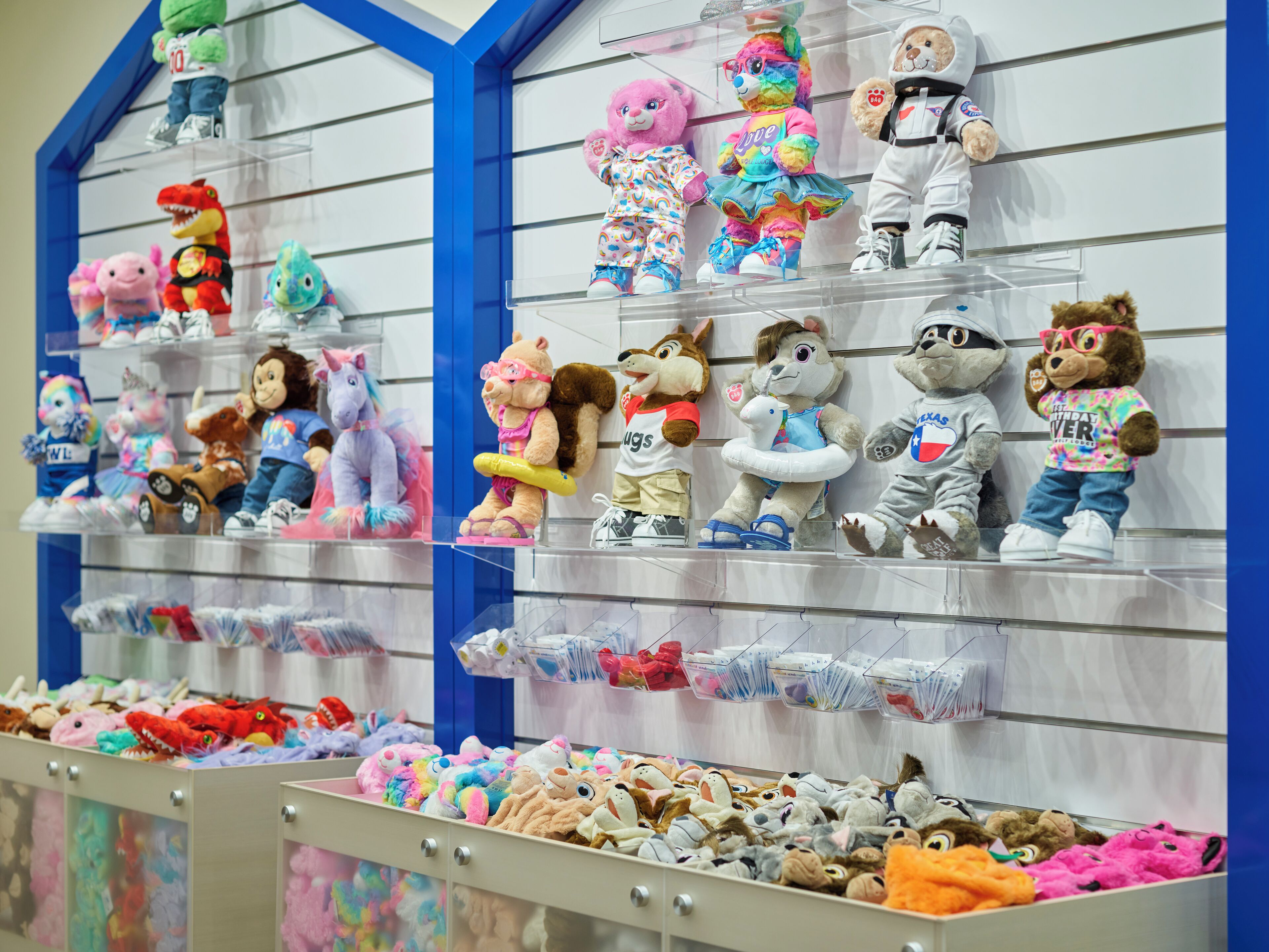 Une exposition de peluches présentées sur des étagères et dans des bacs.