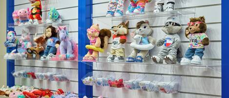 A display of plush toys on shelves and in bins.