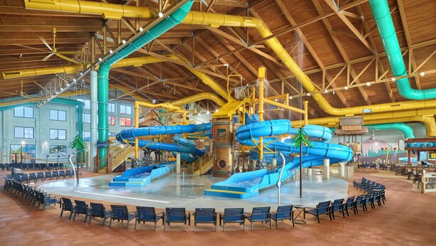 An indoor water park with multiple slides and a seating area around a central pool. - Great Wolf Lodge Webster (Webster)