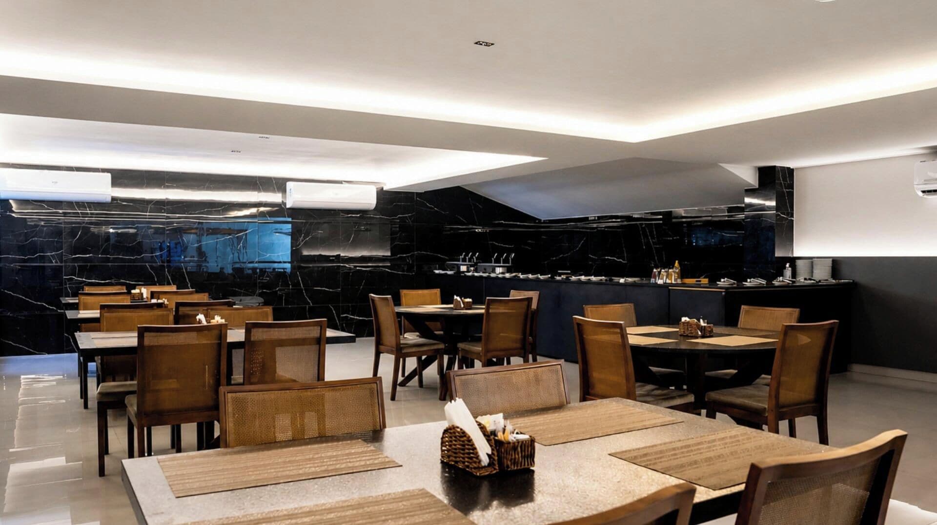 Un ristorante moderno con pareti in marmo, tavoli e sedie in legno.