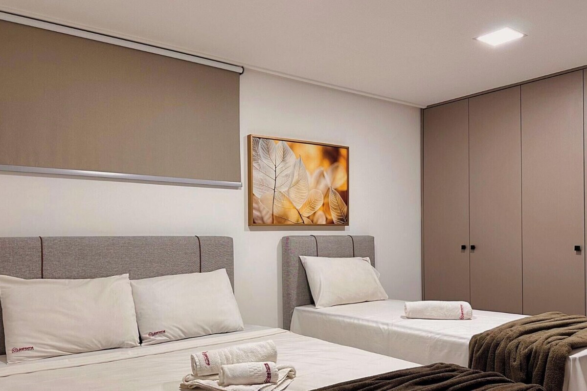 Habitación de hotel con dos camas, un armario grande y un cuadro en la pared.