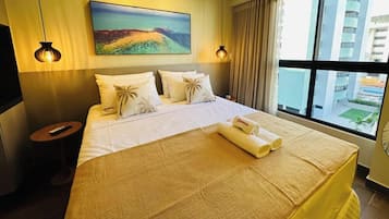 A hotel room with a large bed, a painting on the wall, and a view of buildings through the window.
