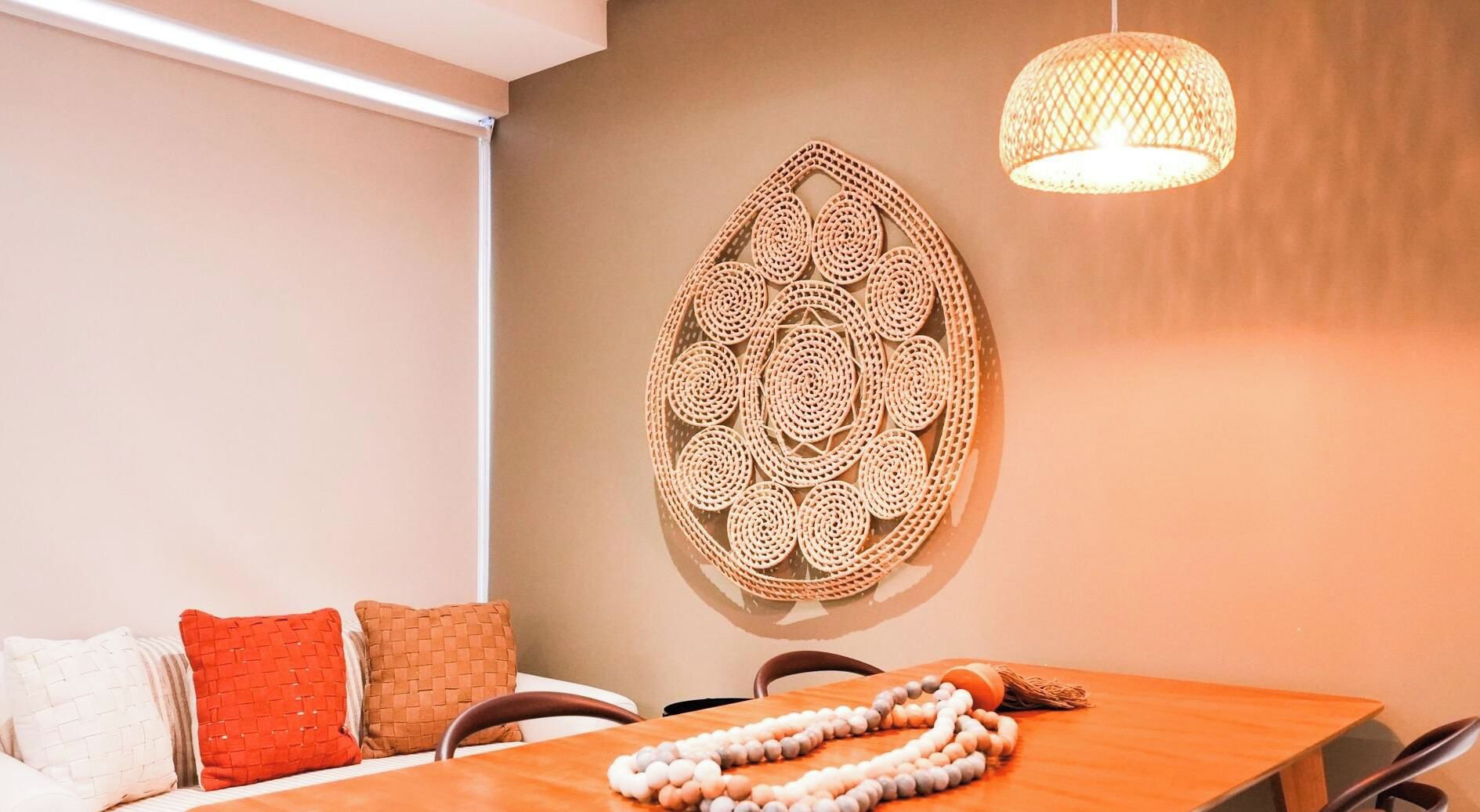 Una habitación con una cama, una mesa, un cuadro en la pared y una lámpara colgante.