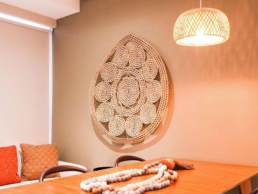 Una habitación con una cama, una mesa, un cuadro en la pared y una lámpara colgante.
