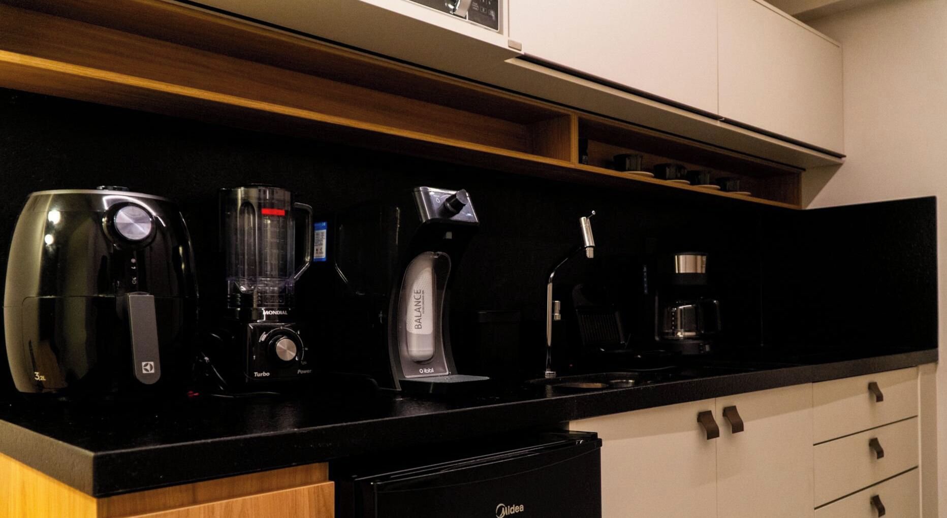 Una encimera de cocina con una cafetera, una licuadora y una máquina de café.