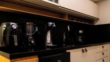 Una encimera de cocina con una cafetera, una licuadora y una máquina de café.