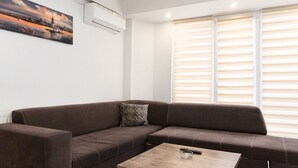 Una sala de estar con un sofá marrón, una mesa de centro y un cuadro en la pared.