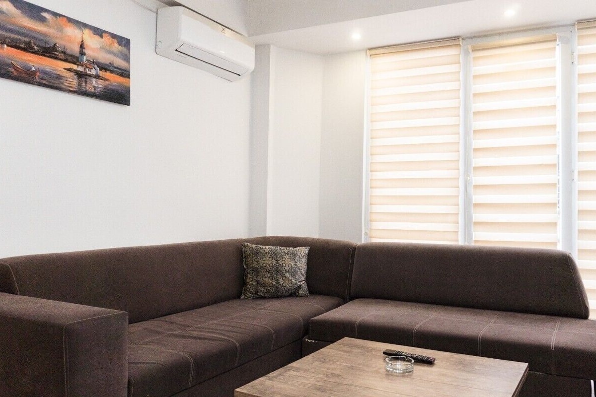 A living room with a brown sofa, a coffee table, and a painting on the wall.