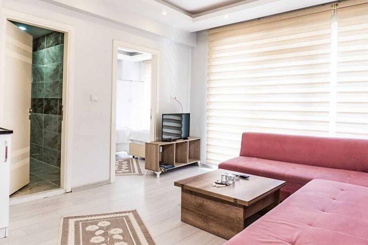 A modern living room with a sofa, coffee table, and a television on a wooden cabinet.