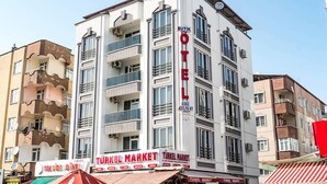 Un edificio de varios pisos con un letrero llamativo para 'Butik OTE' y 'Turk O Market' en la planta baja.