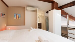 Ein Hotelzimmer mit einem großen Bett, einem Gemälde an der Wand und einem Holzbalken an der Decke.