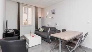 A modern living room with a sofa, a coffee table, and a dining table with chairs.