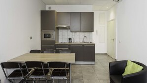Una cucina moderna con isola centrale, elettrodomestici integrati e zona pranzo con sedie.