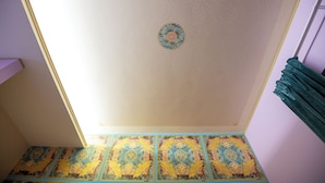 A room with a patterned floor and a ceiling with a central decorative element. - Room with terrace 1 (Tuscania)