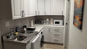 A compact kitchen with white cabinets, a built-in oven, a microwave, and a sink. - Private entrance in-law apartment located minutes from WEC-Ocala. (Ocala)