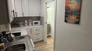 A modern kitchen with white cabinets, a microwave, and a kettle on the counter. - Private entrance in-law apartment located minutes from WEC-Ocala. (Ocala)