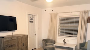 A bedroom with a bed, a TV, a wooden dresser, a desk, and two chairs. - Private entrance in-law apartment located minutes from WEC-Ocala. (Ocala)