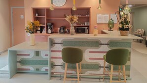 A modern kitchen with a central island, bar stools, a clock, and various kitchen appliances. - DOMITYS - La Flânerie (Béthune)
