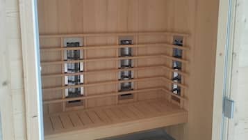 A sauna room with wooden walls and benches.