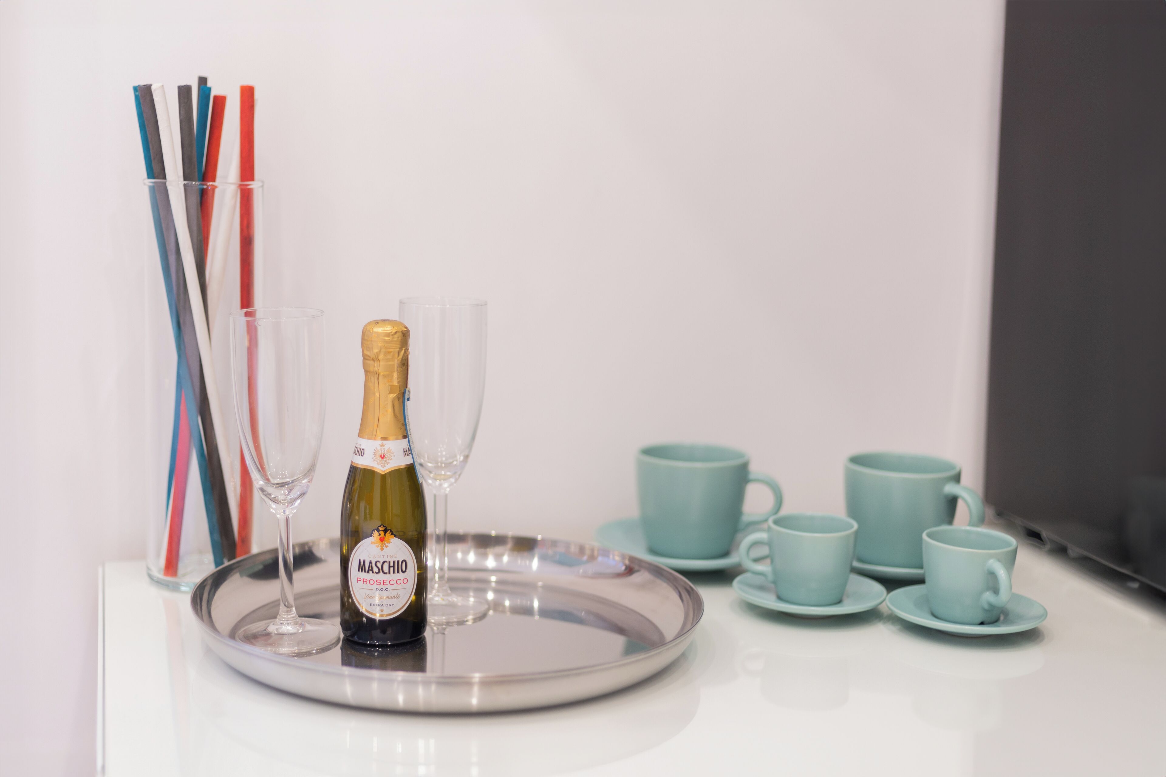 Eine Flasche Maschio Prosecco auf einem Tablett mit Gläsern und türkisfarbenen Tassen.