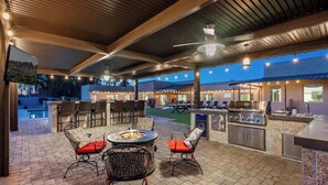 An outdoor patio with a fire pit, seating, and a grill area. - Resort-Style Escape: Pool, Courts, and Endless Fun (Scottsdale)