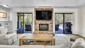 A living room with a fireplace, a sofa, a coffee table, and a television.
