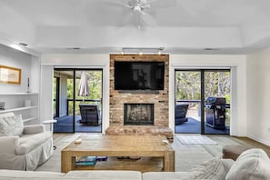 A living room with a fireplace, a sofa, a coffee table, and a television.