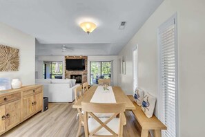 Amplia sala de estar con una mesa de comedor de madera, un sofá y una chimenea.