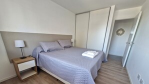 Une chambre à coucher avec un lit, une table de chevet et une armoire.