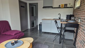 A compact kitchen with a dining area, a sofa, and a coffee table.